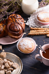 Homemade pastry with cocoa and milk on wooden table, decorated with heather.