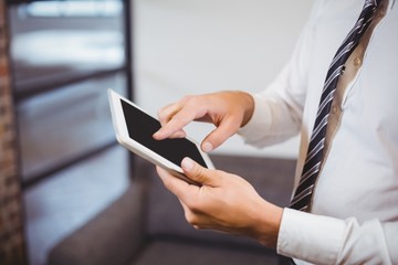 Midsection of businessman using digital tablet in office