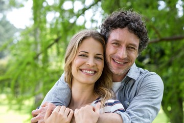Smiling couple embracing in park
