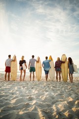 Friends holding surfboard on the beach