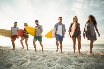Friends holding surfboard on the beach