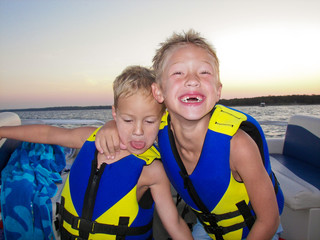 Two adorable boys on a lake at sunset.
