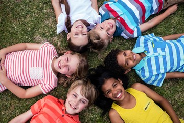 Happy children lying on grass