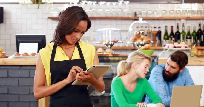 Smiling waitress holding a tablet
