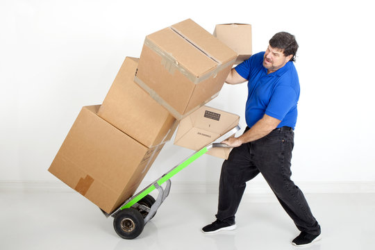 Man moving boxes with a hand cart or dollie and dropping them