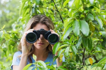 Young woman looking through binocular 