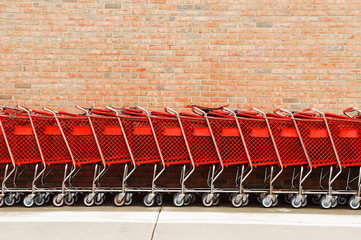 shopping cart in a row in front of brick wall