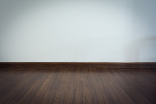empty room, white mortar wall background and wood laminate floor