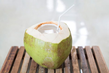 Young coconut on wooden table.