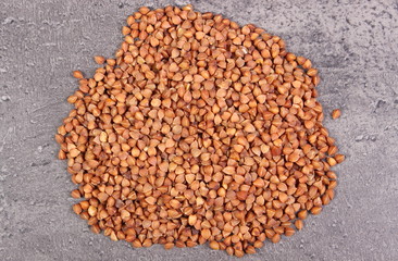 Heap of buckwheat groats on cement structure