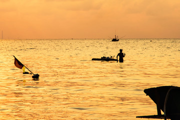 Silhouette of local fisherman walking on the sea