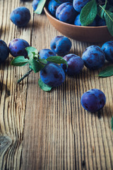 Fresh organic plums on  wooden table