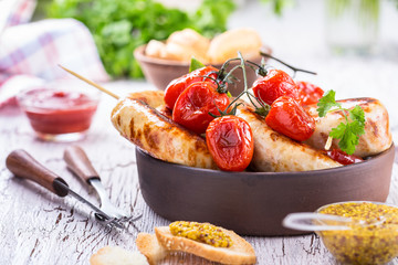 Grilled sausages and tomatoes in rustic style