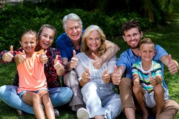 Potrait of family gesturing thumbs up at yard 