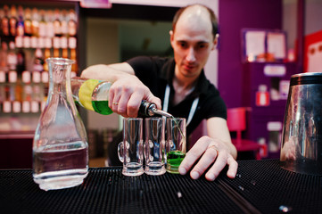 Barman preparing green mexican cocktail drink at the bar