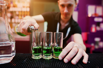 Barman preparing green mexican cocktail drink at the bar