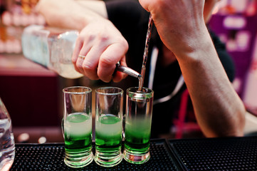 Close up barman hands  preparing green mexican cocktail drink at