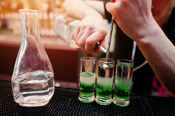 Close up barman hands  preparing green mexican cocktail drink at