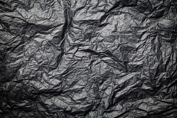 The dark texture of crumpled paper, black background