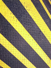 yellow and black warning metal barricade with diagonal line pattern