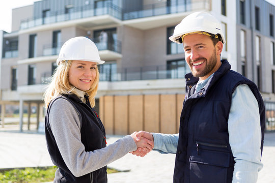 architect and worker handshaking on construction site