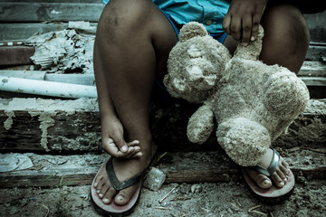 Vintage tone,Sad boy sitting alone with old teddy bear