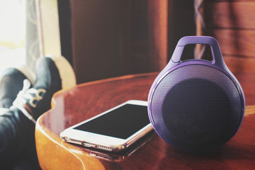 Woman using bluetooth speaker with smart phone