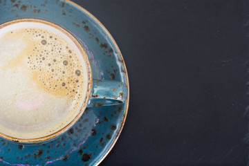 Coffee with milk, cappuccino in a blue retro cup.