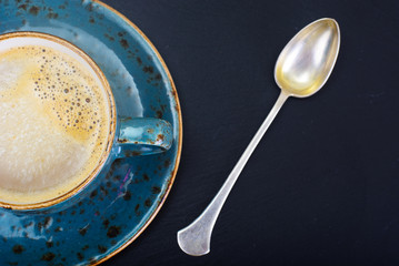 Coffee with milk, cappuccino in a blue retro cup.