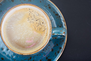 Coffee with milk, cappuccino in a blue retro cup.