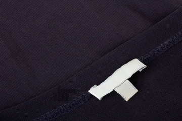 white tag on black clothes or fabric closeup