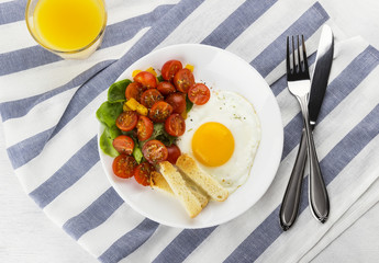 Breakfast: fried eggs with tomatoes and pepper on a white backgr