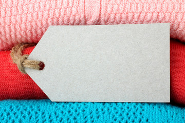 white tag on a stack of colorful folded clothes closeup