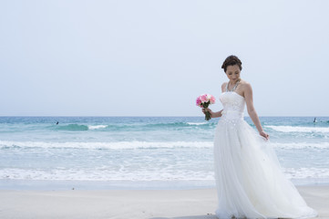 Fototapeta na wymiar Bride wearing a wedding dress are in the beach
