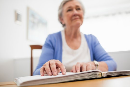 Blind senior woman using braille to read