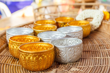 Gold and silver bowl on wooden basket.
