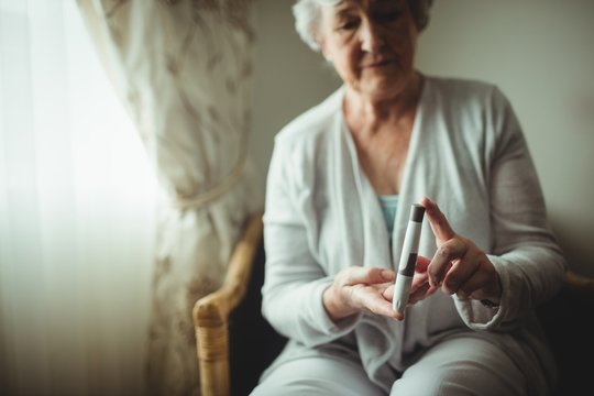 Senior woman holding a blood glucose monitor