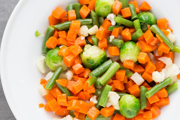 Fresh vegetables mix in a white bowl.