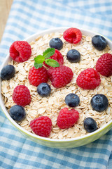 Oatmeal porridge with berries. Raspberries and blueberries.