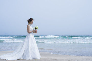 Fototapeta na wymiar Beautiful bride you are taking wedding photos at the beach
