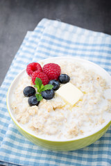 Oatmeal porridge in bowl with berries raspberries and blackberri