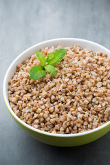Buckwheat porridge in a bowl with mint leaves and blueberries.