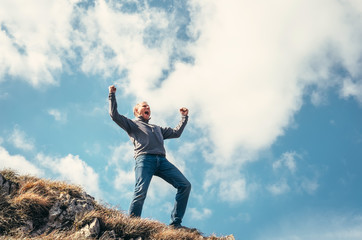 Triumphed man on the top of mountain peak