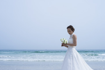 Fototapeta na wymiar Beautiful bride, sea, sky, wedding dress