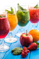 healthy colorful smoothies with fresh fruits on wooden background. Detox and diet food concept and background