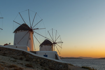 Fototapeta na wymiar Amazing Sunset and White windmills on the island of Mykonos, Cyclades, Greece