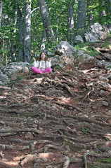 little girl meditating in the forest