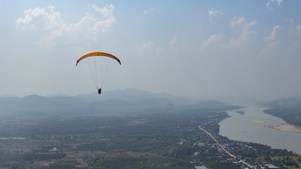 silhouette human is parachuting from the top of mountian