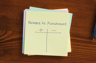Reward vs punishment written on a note