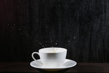 white cup of splashing milk